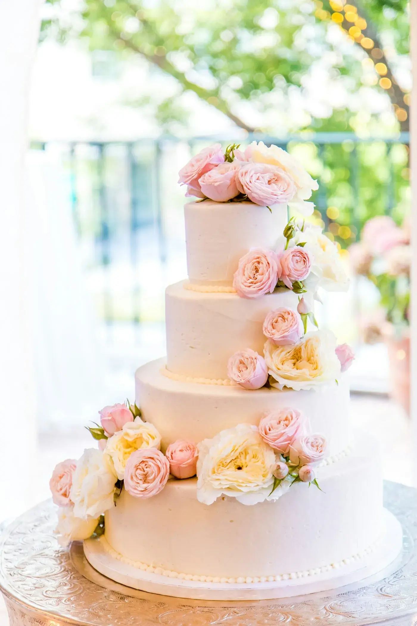 Four-tier wedding cake with pastel roses